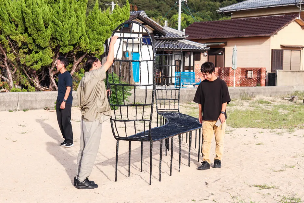 海辺にたたずむ大きなベンチに興味津々のメンバーの様子