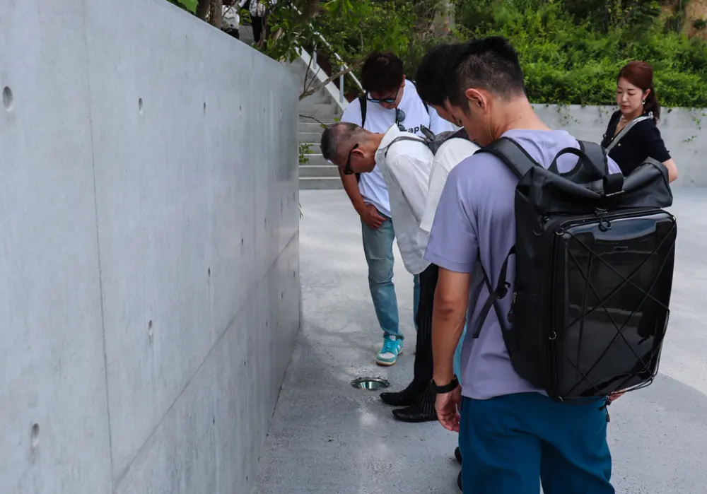 直島新美術館の入り口に設置された照明が気になる企画チームの様子